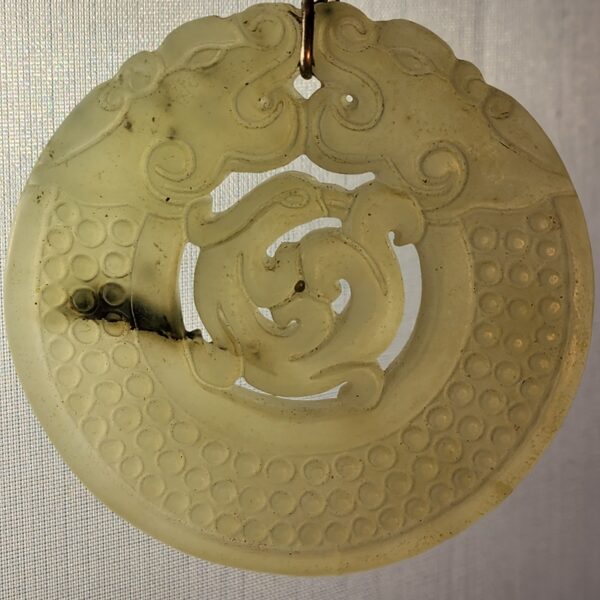 Carved stone ornament with leather cord